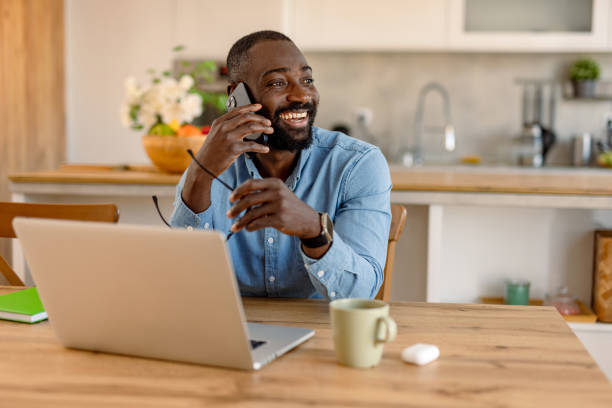 istock Young black man working from home and talking on the phone 2193017333