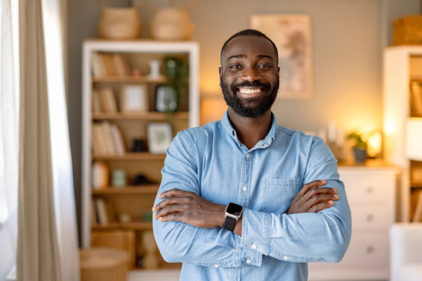 istock Confident young man smiling with arms crossed at home 2193017380