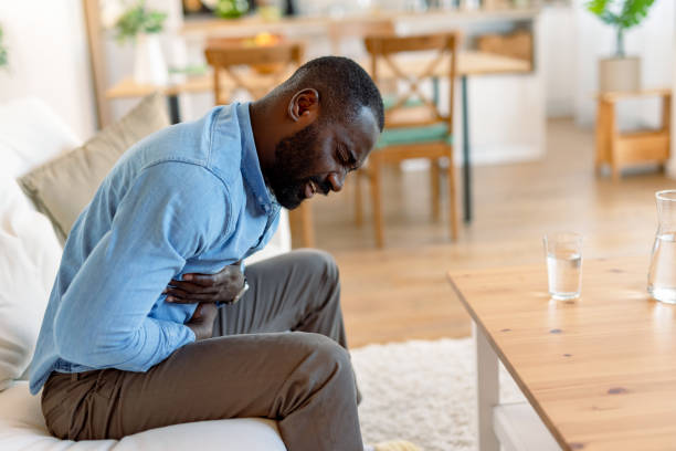istock Young black man suffering from stomach ache at home 2193017415