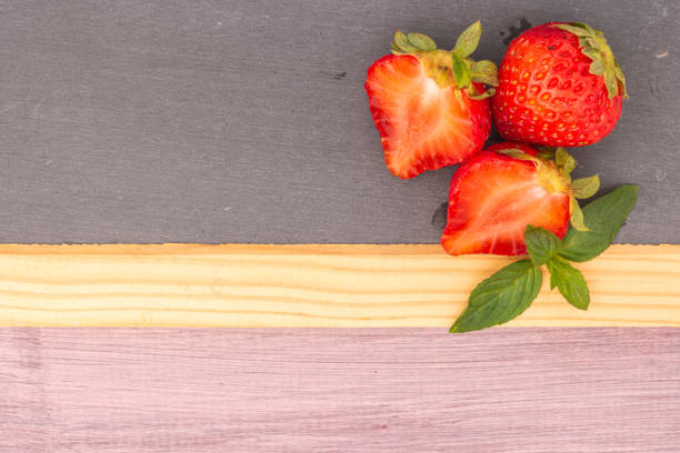Fresh strawberries in bowl on slate. Top view with copy space
