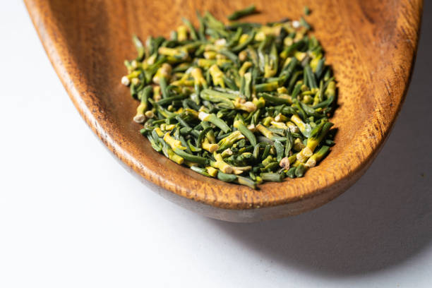 large green tea poured into a wooden cup with the addition of fruits and berries, dry high-quality expensive tea in a wooden bowl