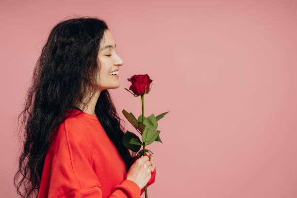 istock Happy young woman smelling red rose on pink background, copy space 2193025582