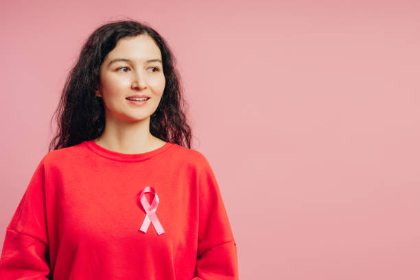 istock Woman wearing pink ribbon supporting breast cancer awareness looking away smiling 2193025607