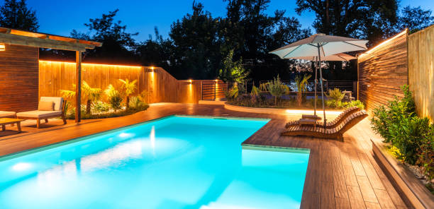 istock Modern pool with illuminated seating area at night. Concept of luxurious evening relaxation and outdoor ambiance 2193033590