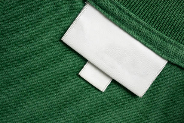 istock Blank white laundry care clothes label on green shirt fabric texture background 2193035161