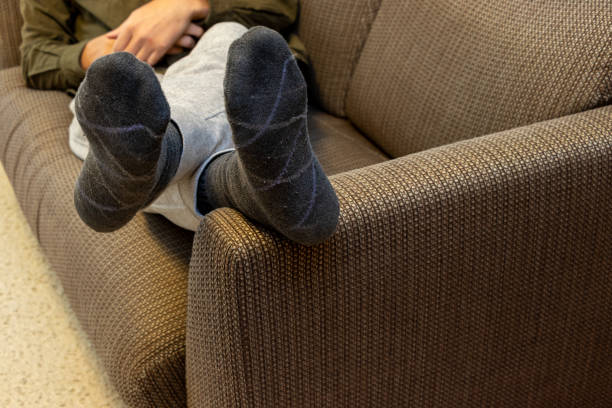 istock Man lying on sofa with feet up on armrest 2193035368