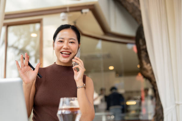istock A beautiful, confident Asian woman talks in the phone while working remotely from a cafe. 2193038690