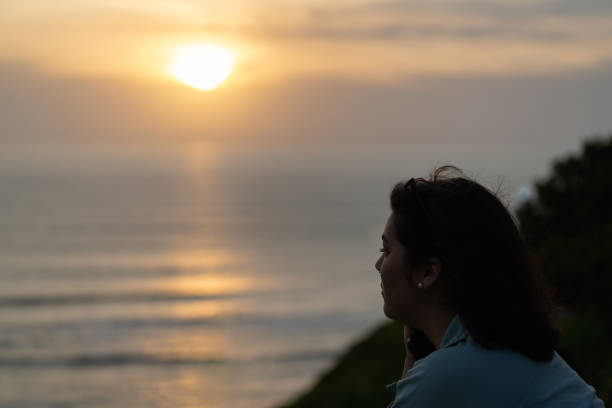 istock Young woman meditating by the sea at sunset after work 2193040755