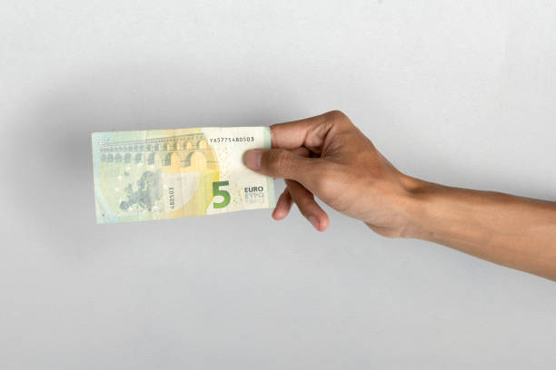 Human hand holding five euro banknote cash on white background