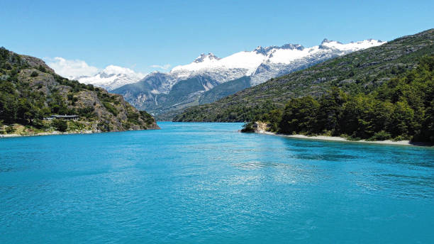 “Chilean Patagonia: Bertrand Lake and Snow-Capped Peaks” “Stunning image of Bertrand Lake in Chilean Patagonia, featuring crystal-clear turquoise waters surrounded by lush mountains. In the background, snow-capped peaks of the Andes complete the breathtaking scenery. Perfect for projects about nature, remote landscapes, and adventure tourism.” carretera austral chile stock pictures, royalty-free photos & images