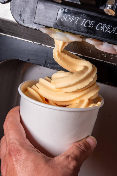 Human hand holding a container of Organic frozen yogurt while self serving it