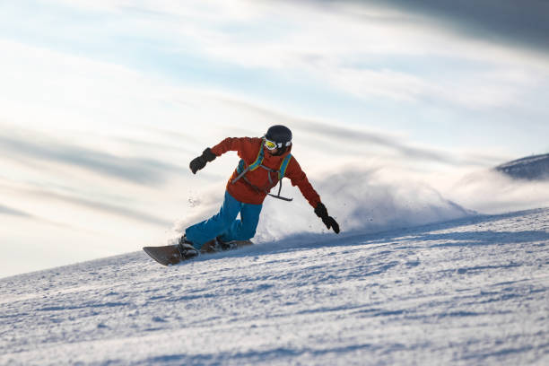 Mid adult men snowboarding in mountain