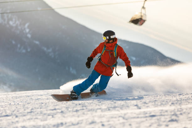 istock Mid adult men snowboarding in mountain 2193052380