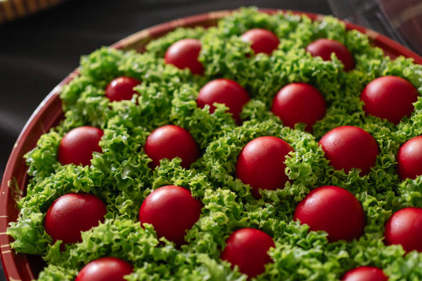 Red eggs displayed on a red tray, each nestled in lettuce for decoration.