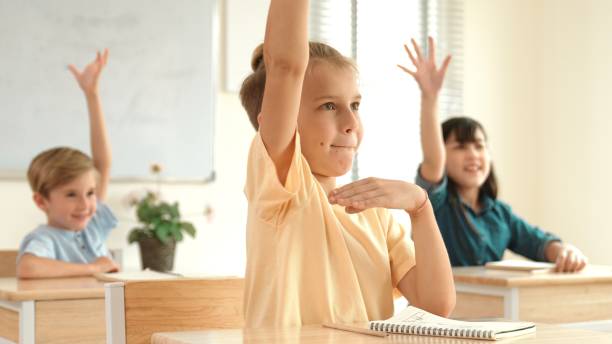 istock Serious student raised hand up to answering question at classroom. Pedagogy. 2193053465