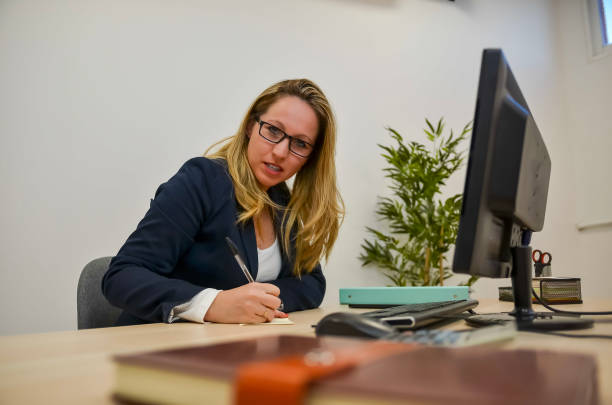 istock Young businesswoman taking notes at her desk 2193054956