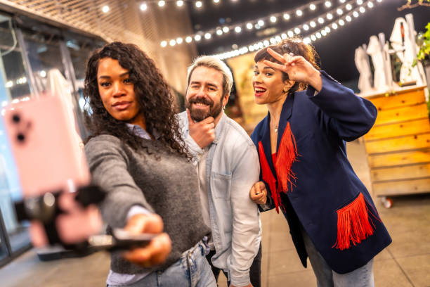 istock Friends gesturing success while streaming online video at night outdoors 2193056988