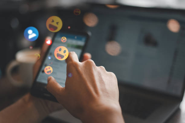 istock Person Using Smartphone with Emoji Reactions 2193060547