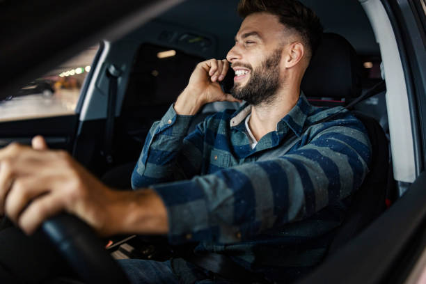 istock Happy man driving a car and talking on his phone. 2193062234