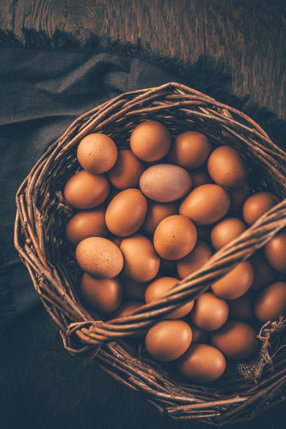 istock Organic brown eggs in a basket on wooden table 2193064704