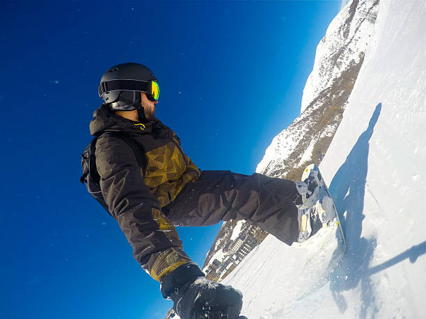 Awesome snowboarder jumps of a cliff in Les Portes du Soleil in France
