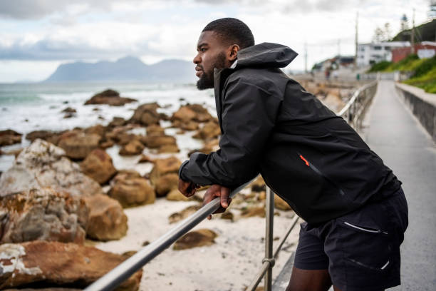 istock Man leaning on railing after running on coastal path 2193066460