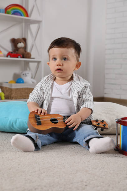 istock Cute little boy with toy guitar at home 2193066685
