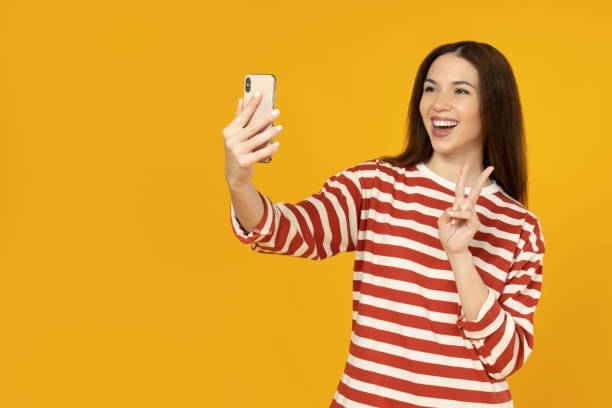istock A girl with a phone on a yellow background. 2193067181