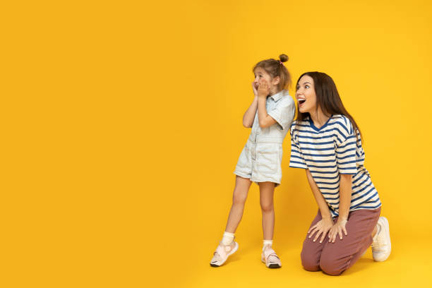 istock Mother and daughter are playing, on a yellow background. 2193067224
