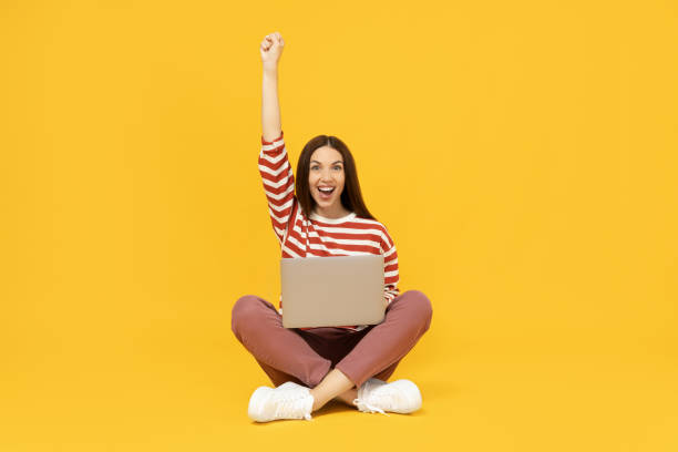 istock Happy girl with a cardboard box, a parcel, on a yellow background. 2193068069