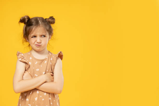 istock Upset little girl on a yellow background 2193068277