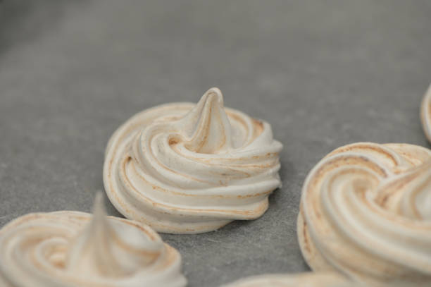 istock Whipped meringue kisses drying on parchment paper in a cozy kitchen setting 2193069029