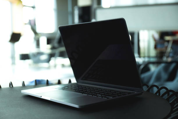 istock Laptop on black table in coworking space, close up 2193070711