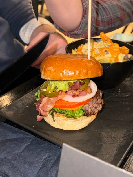 Friends eating Burger in a restaurant enjoying fast food gourmet bun patty with side dish