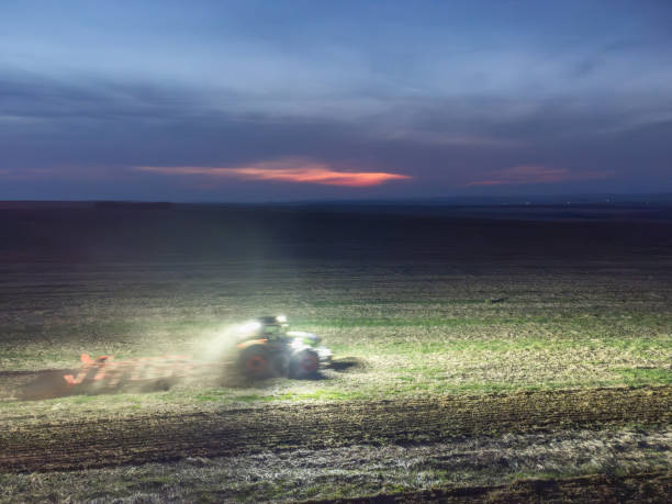 istock Tractor in the field in the night 2193071909