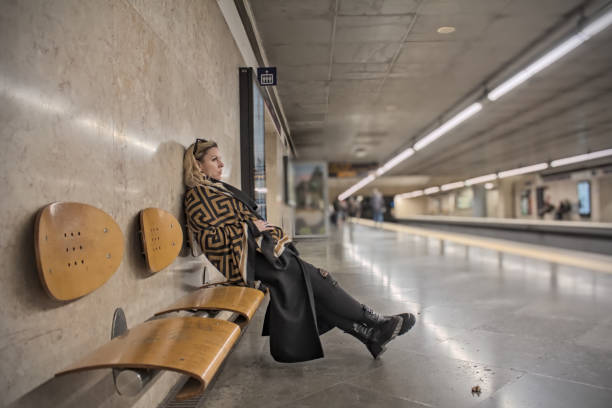 Alone woman waiting for a commuting metro train on a subway station panoramic view, Lisbon, Portugal