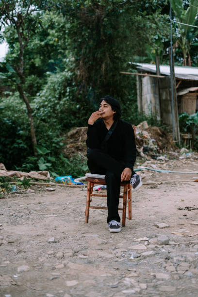 istock A Southeast Asian man sitting alone on a chair, smoking 2193073942