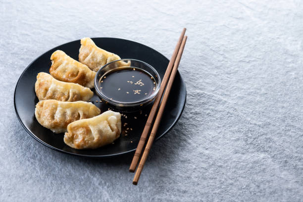 istock Fried dumplings gyoza with soy sauce on grey stone background 2193079317