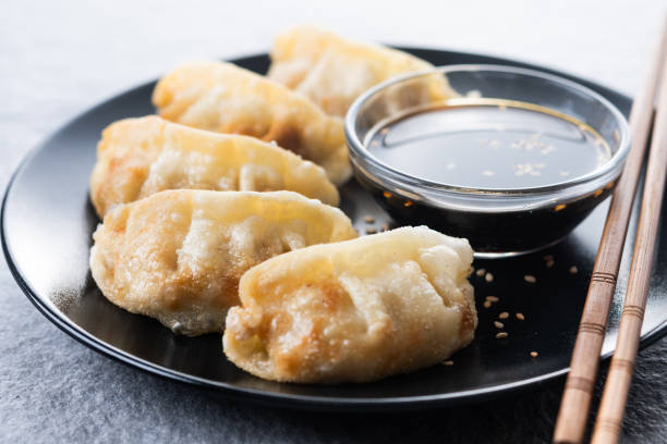 istock Fried dumplings gyoza with soy sauce on grey stone background 2193079345