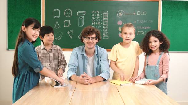 istock Teacher and student looking at camera while boy standing at board. Pedagogy. 2193080316