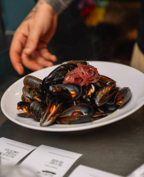 istock Steamed mussels on a white plate in a restaurant. Restaurant 2193084504