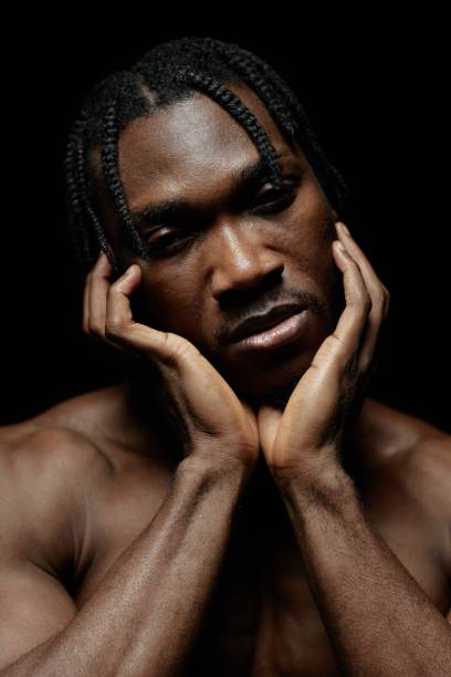istock Portrait of Graceful Black Man Touching Face Posing in Contrast Light 2193086332