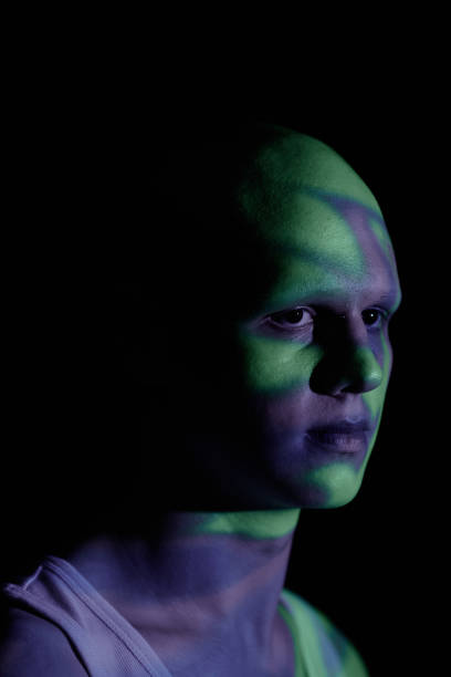 istock Portrait of Man Looking away Standing in Blue Projector Light in Dark Studio 2193086395
