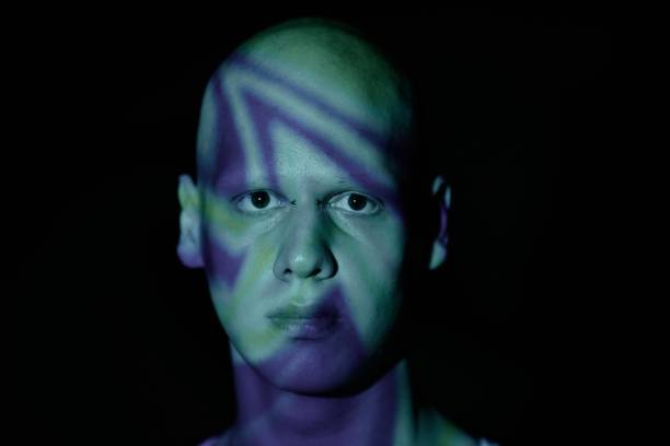 istock Portrait of Man with Scary Appearance Looking at Camera Standing in Blue Projector Light 2193086401