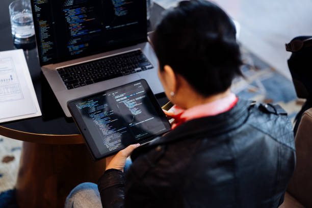 istock Rear view of Asian software engineers working together with digital tablet and laptop at hotel cafe. 2193089301