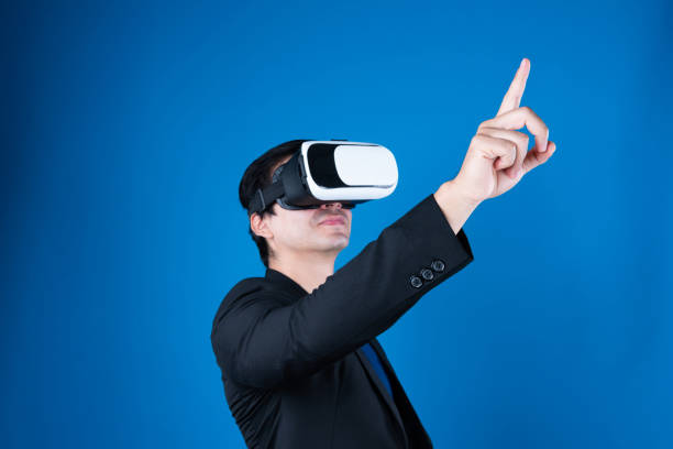 Profile businessman wearing VR headset looking to connect metaverse pointing to choose interesting data isolated blue background futuristic analytics communication tech virtual reality. Contrivance.