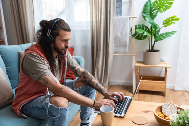 istock Handsome man listening to the music while working on a computer. Freelance IT security computer programer, global business professional occupation worker, work in home office on laptop. 2193090967