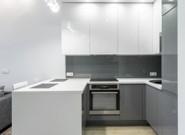 istock Modern kitchen with white and gray cabinets, a sleek countertop, and built-in appliances. Minimalist design. Home Interior 2193092664