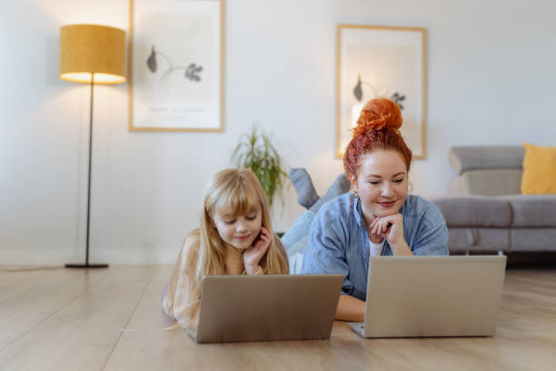 istock Mother and daughter bonding while using laptops together in a cozy home setting 2193092727