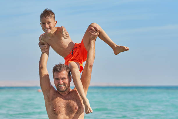 Father and the son having fun in the sea. High quality photo